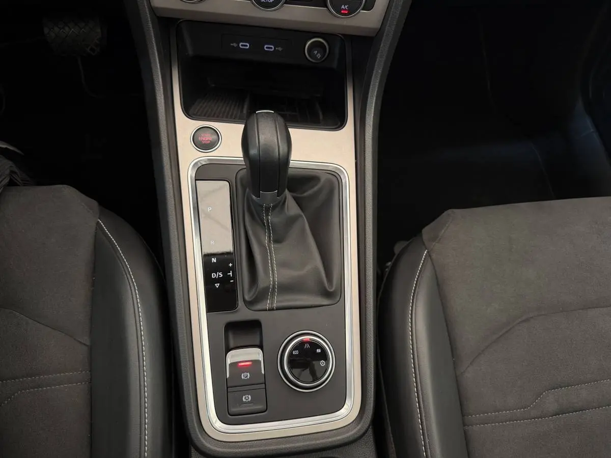 Vue rapprochée de la console centrale du SEAT Ateca gris clair 2023, avec levier de vitesses automatique et commandes de mode de conduite.