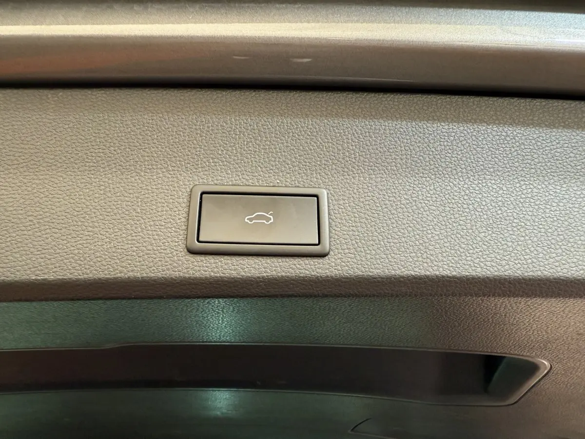 Bouton d'ouverture électrique du coffre sur la garniture intérieure grise du SEAT Ateca 2023.