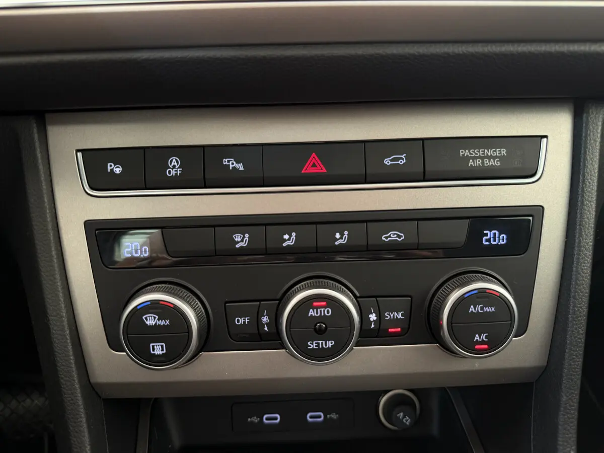 Panneau de commande central de la climatisation du SEAT Ateca gris clair 2023 avec affichage digital et boutons rotatifs.