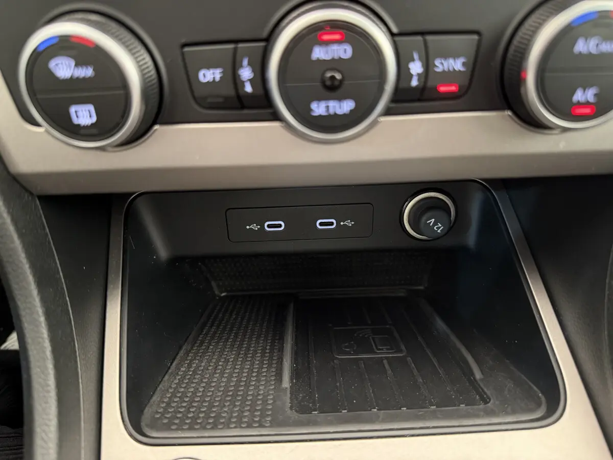 Gros plan sur la console centrale du SEAT Ateca gris clair 2023, montrant les ports USB-C et prise 12V avec commandes climatisation.