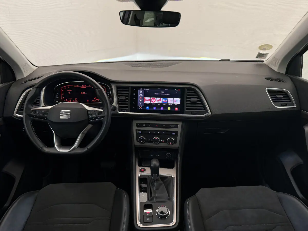 Intérieur noir du SEAT Ateca 2023 vu de face, avec tableau de bord digital et écran tactile central lumineux.