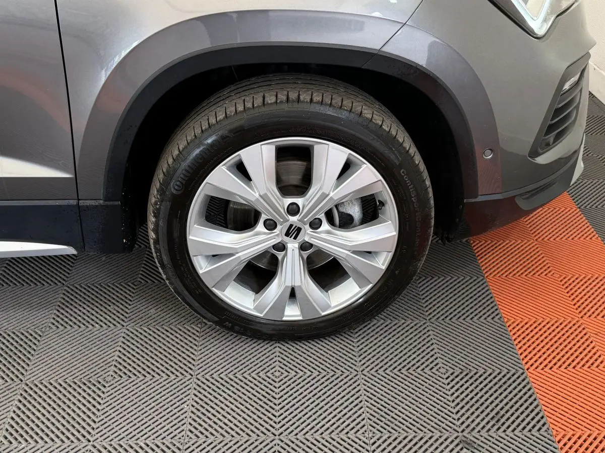 Gros plan sur la roue avant droite gris clair du SEAT Ateca 2023 avec jante alliage et logo central visible.