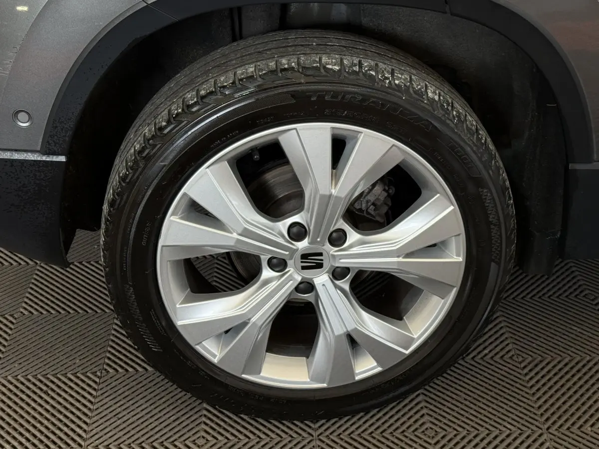 Gros plan sur la roue avant droite du SEAT Ateca gris clair 2023 avec jante alliage à design moderne.