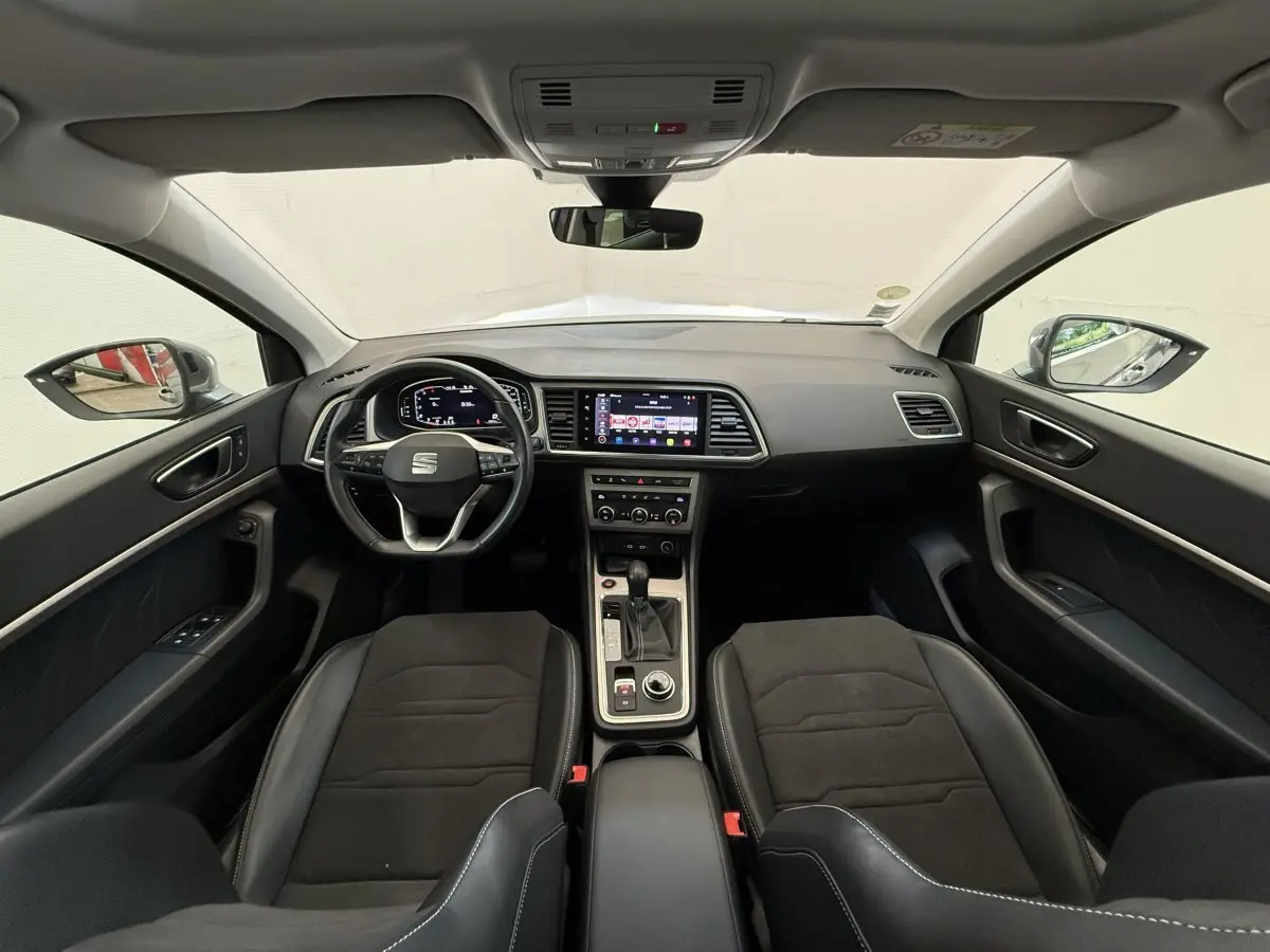 Vue intérieure avant du SEAT Ateca 2023 avec tableau de bord moderne et sièges noirs en alcantara et cuir.