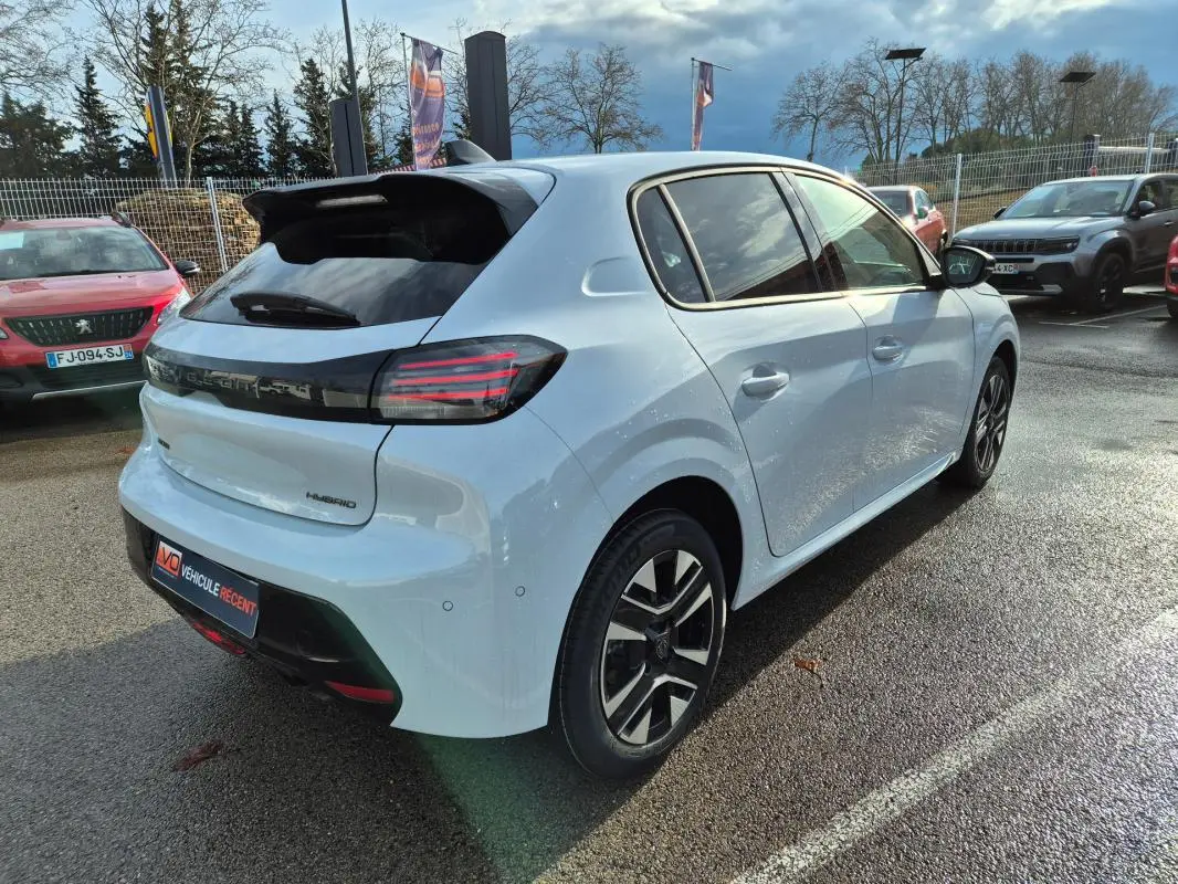 Peugeot 208 Hybrid blanc vue 3/4 arrière droit, jantes alliage 16 pouces et feux arrière LED distinctifs.