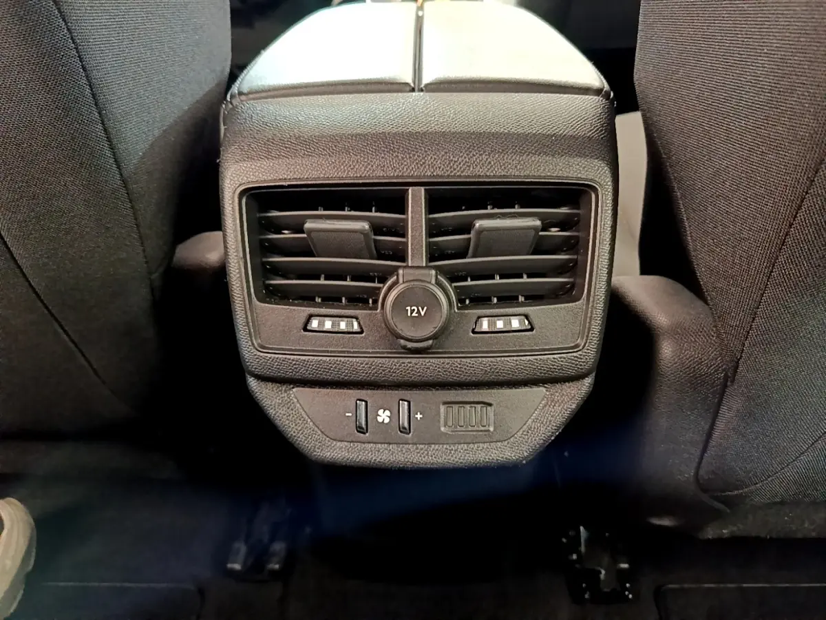 Vue rapprochée des aérateurs arrière et prise 12V noirs entre les sièges arrière du Peugeot 5008 bleu.