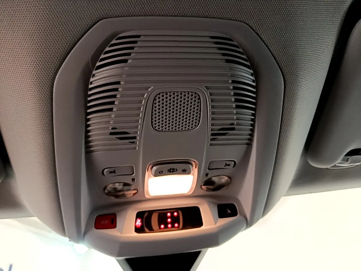 Vue en contre-plongée du plafonnier intérieur gris du Peugeot 5008 bleu avec éclairage et commandes intégrées.