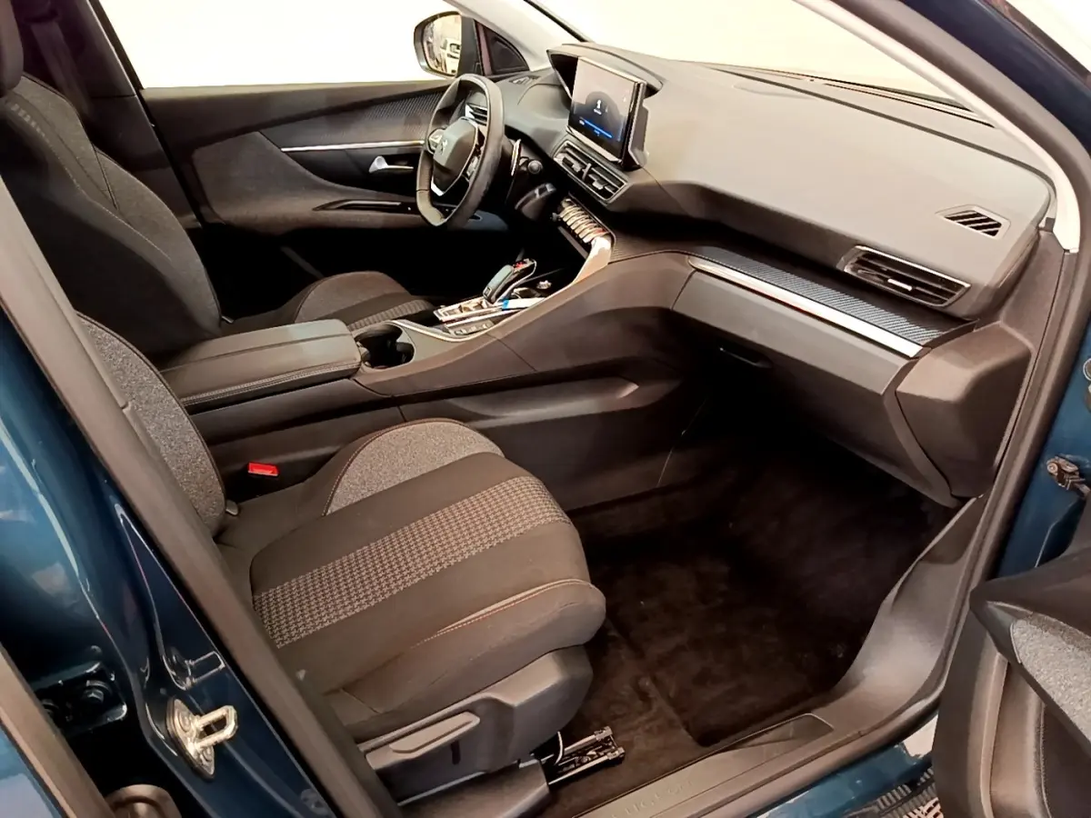 Vue intérieure côté conducteur du Peugeot 5008 bleu 2021, avec volant cuir multifonctions et écran tactile central.