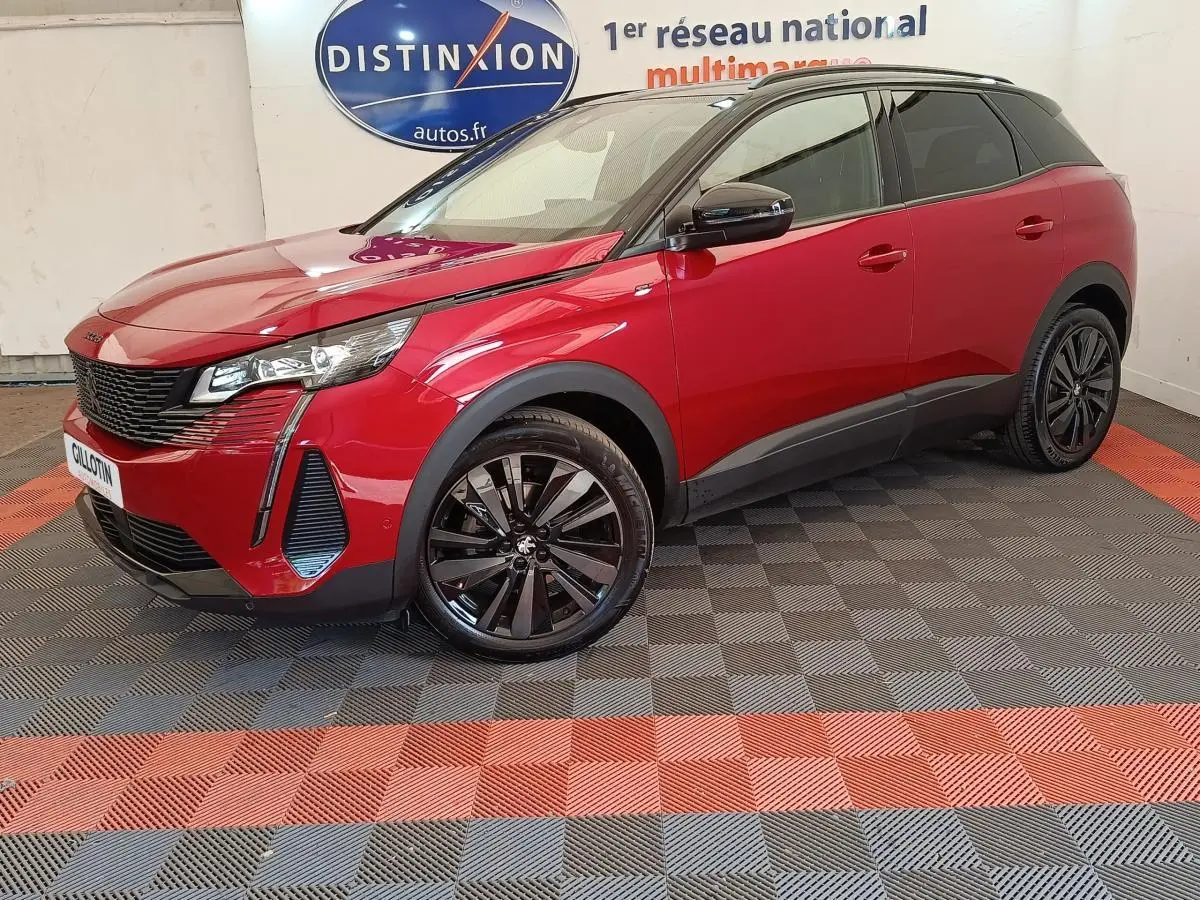 Peugeot 3008 rouge vue 3/4 avant droit, jantes noires et toit noir contrasté dans un showroom.