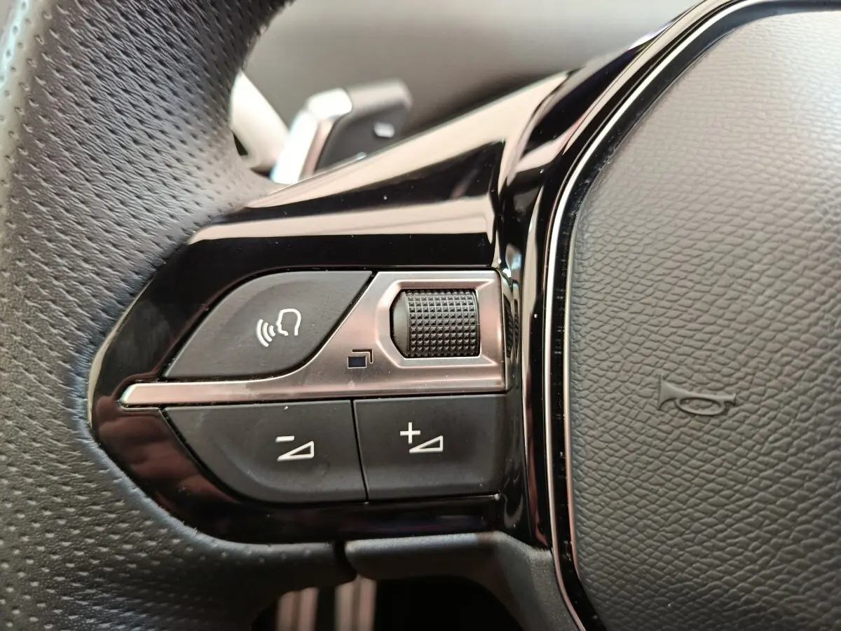 Gros plan sur les commandes vocales et volume du volant cuir noir du Peugeot 3008 GT Pack 2022.