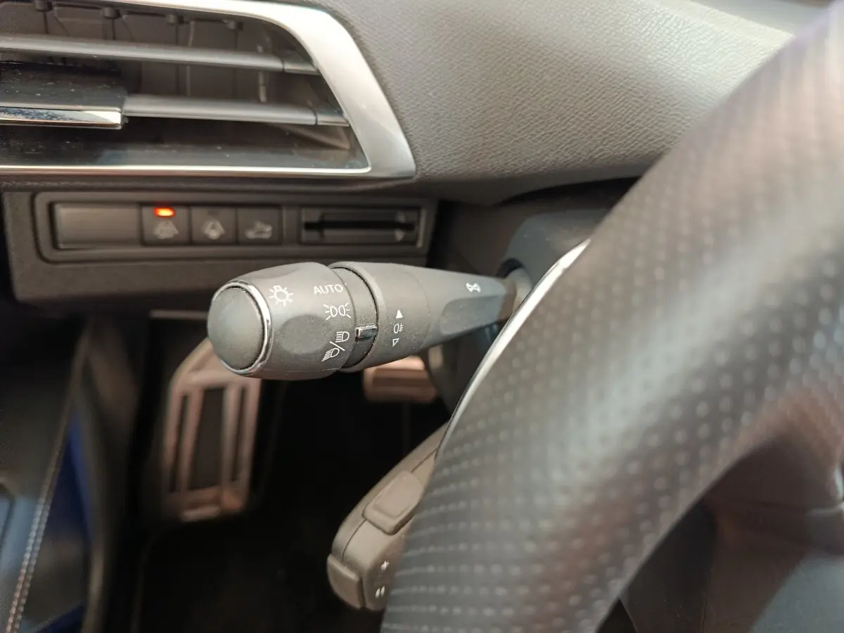 Gros plan sur la commande des phares et clignotants côté gauche du volant du Peugeot 3008 rouge GT Pack 2022.