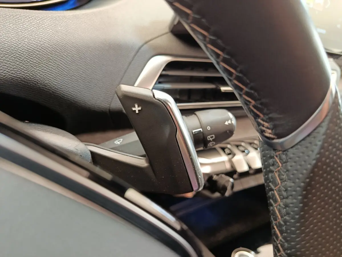 Gros plan sur la palette de changement de vitesse droite en cuir noir avec surpiqûres orange du Peugeot 3008 GT Pack rouge.