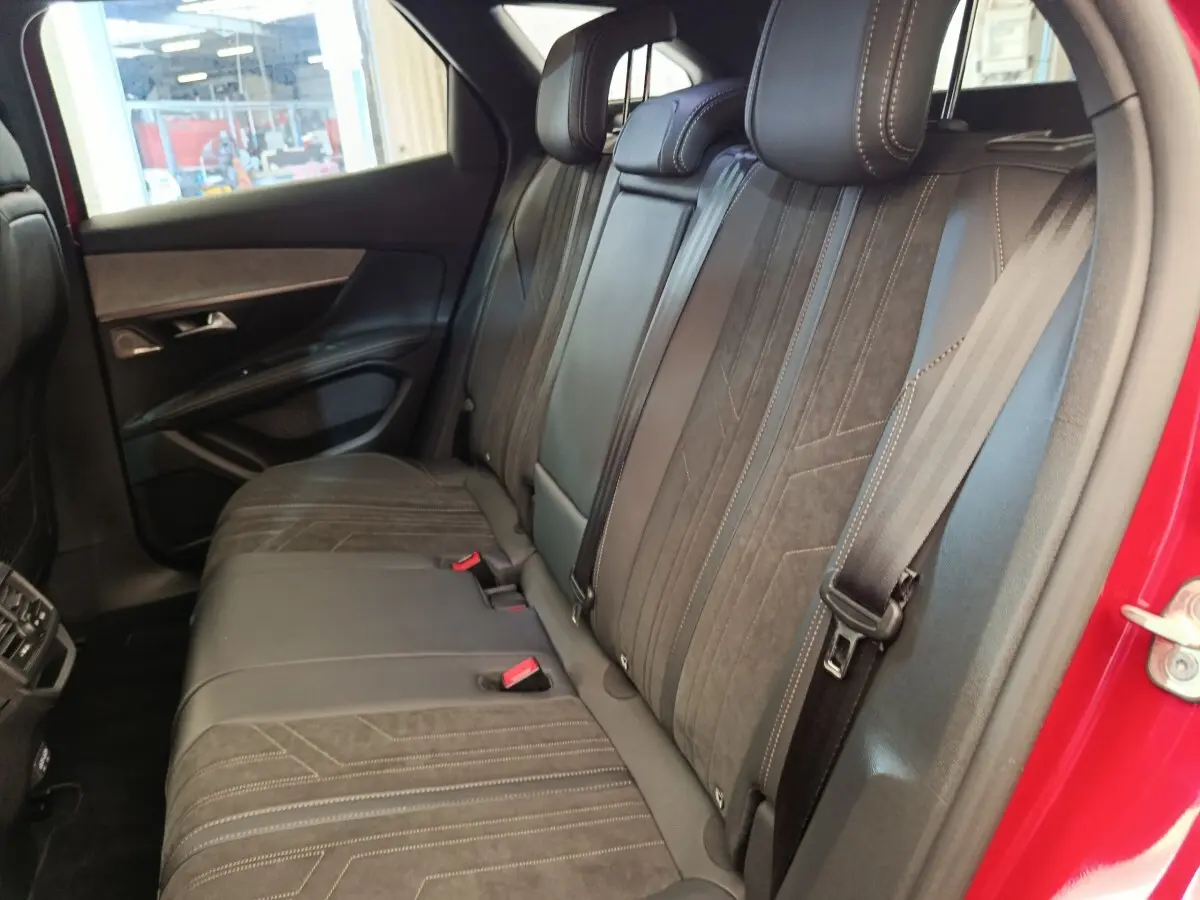 Vue intérieure côté droit des sièges arrière en cuir noir du Peugeot 3008 GT Pack rouge, avec ceinture de sécurité visible.