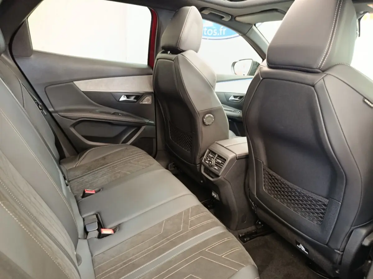 Vue intérieure arrière côté droit du Peugeot 3008 GT Pack 2022 rouge, sièges cuir noirs et ventilation passager visible