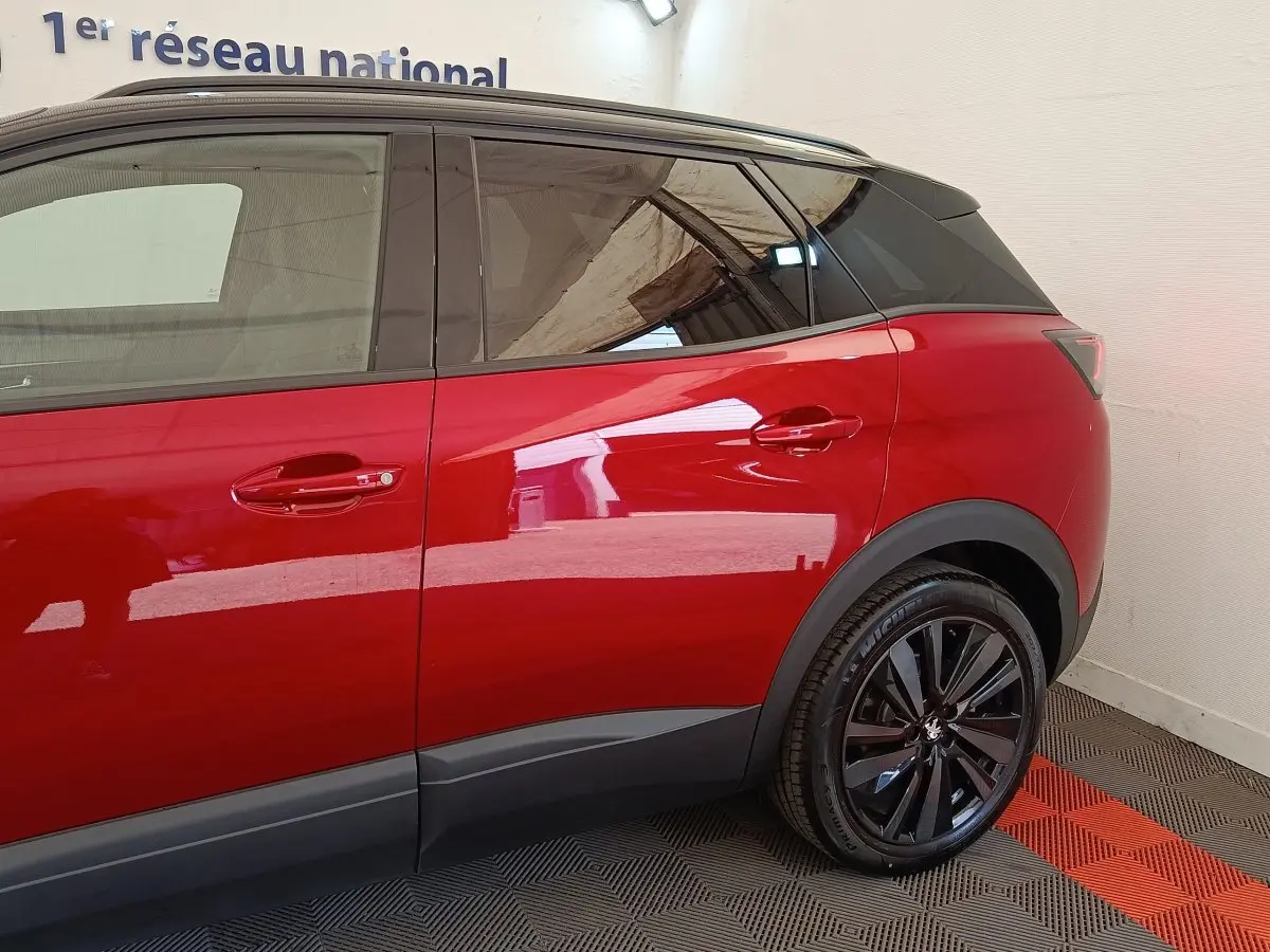 Vue latérale droite sur le Peugeot 3008 rouge, mettant en valeur les jantes noires et les vitres teintées.
