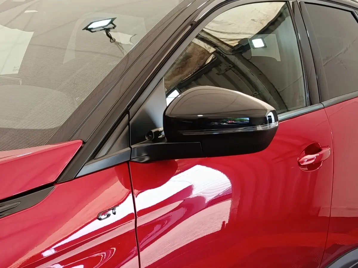 Détail du rétroviseur noir et porte rouge côté conducteur du Peugeot 3008 GT Pack 2022.
