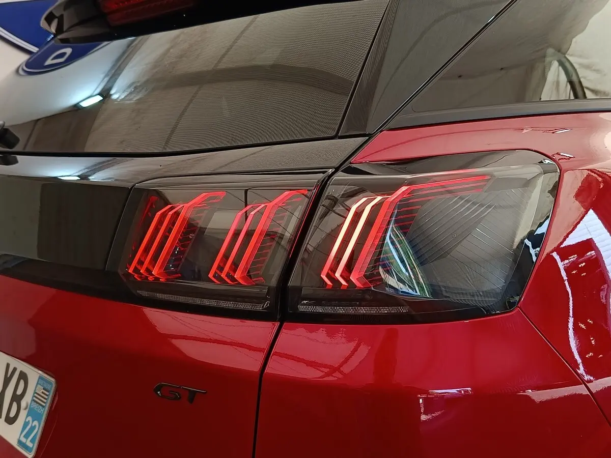 Gros plan sur le feu arrière droit rouge brillant d’un Peugeot 3008 GT Pack 2022 avec logo GT visible.