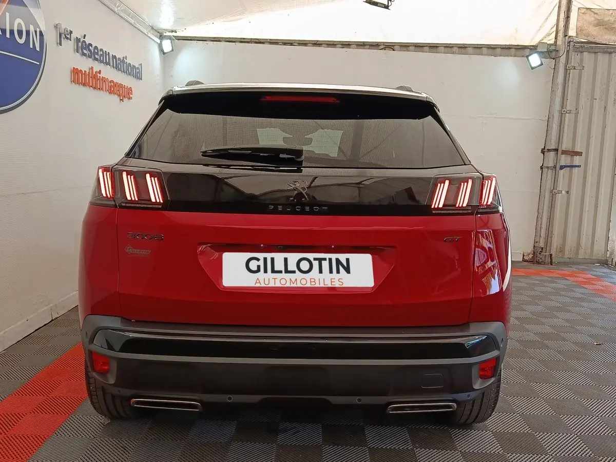 Vue arrière d'un Peugeot 3008 GT Pack rouge avec feux LED caractéristiques et double sortie d'échappement.