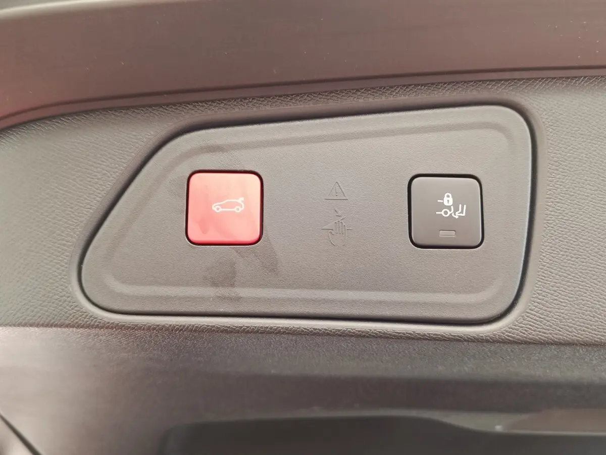 Gros plan sur les boutons de commande de coffre et verrouillage des sièges du Peugeot 3008 GT Pack rouge, intérieur noir.