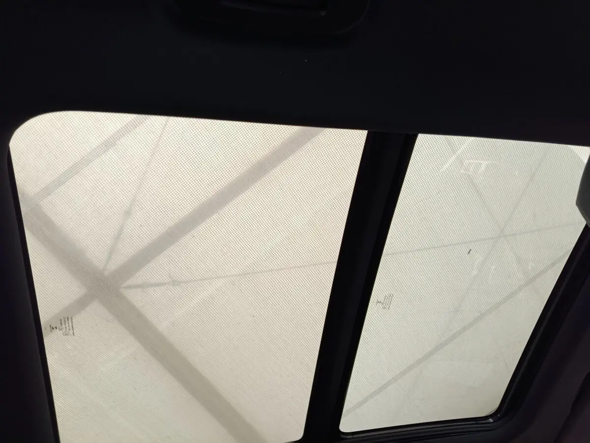 Toit panoramique avec store occultant du Peugeot 3008 GT Pack rouge, vue intérieure vers le haut.