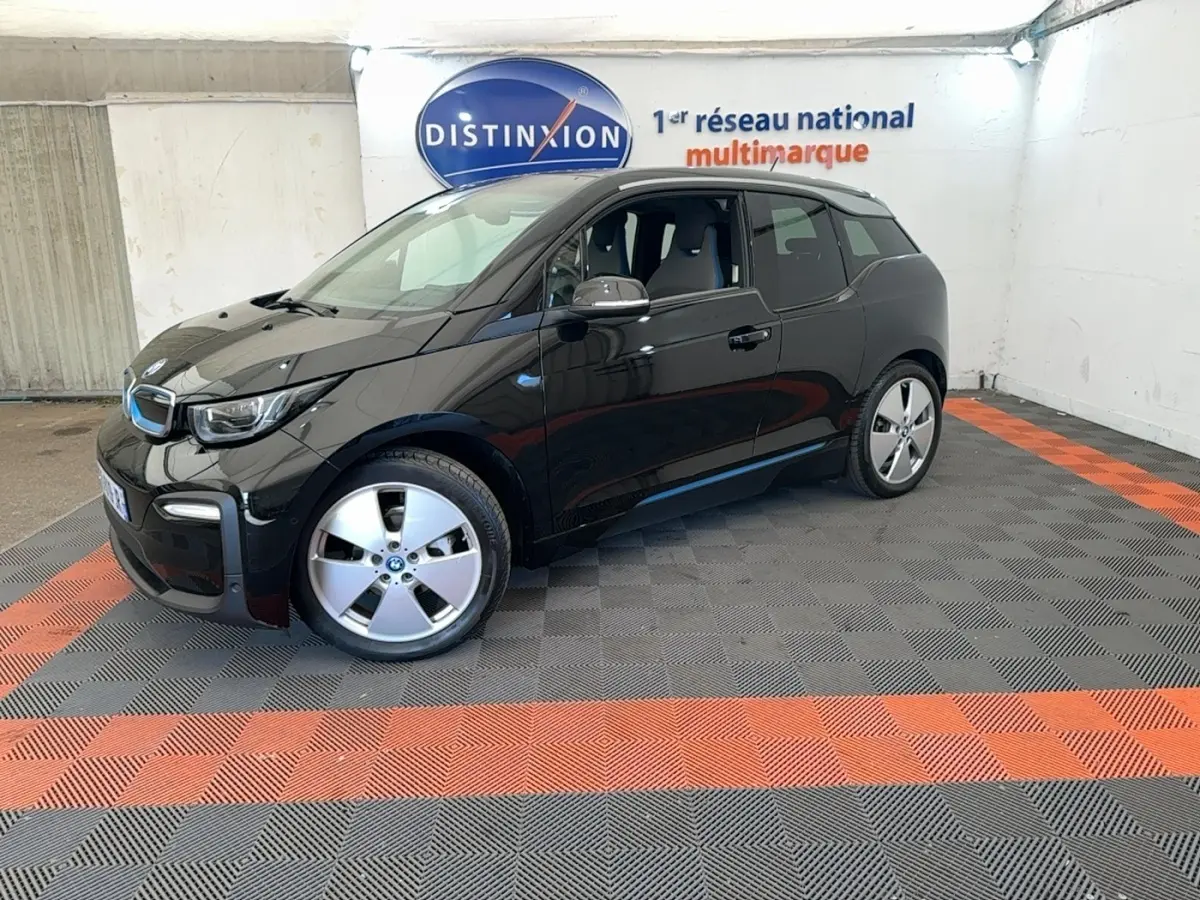BMW i3 120 Ah noir vue 3/4 avant droit, avec jantes spécifiques et logo bleu électrique sur calandre.
