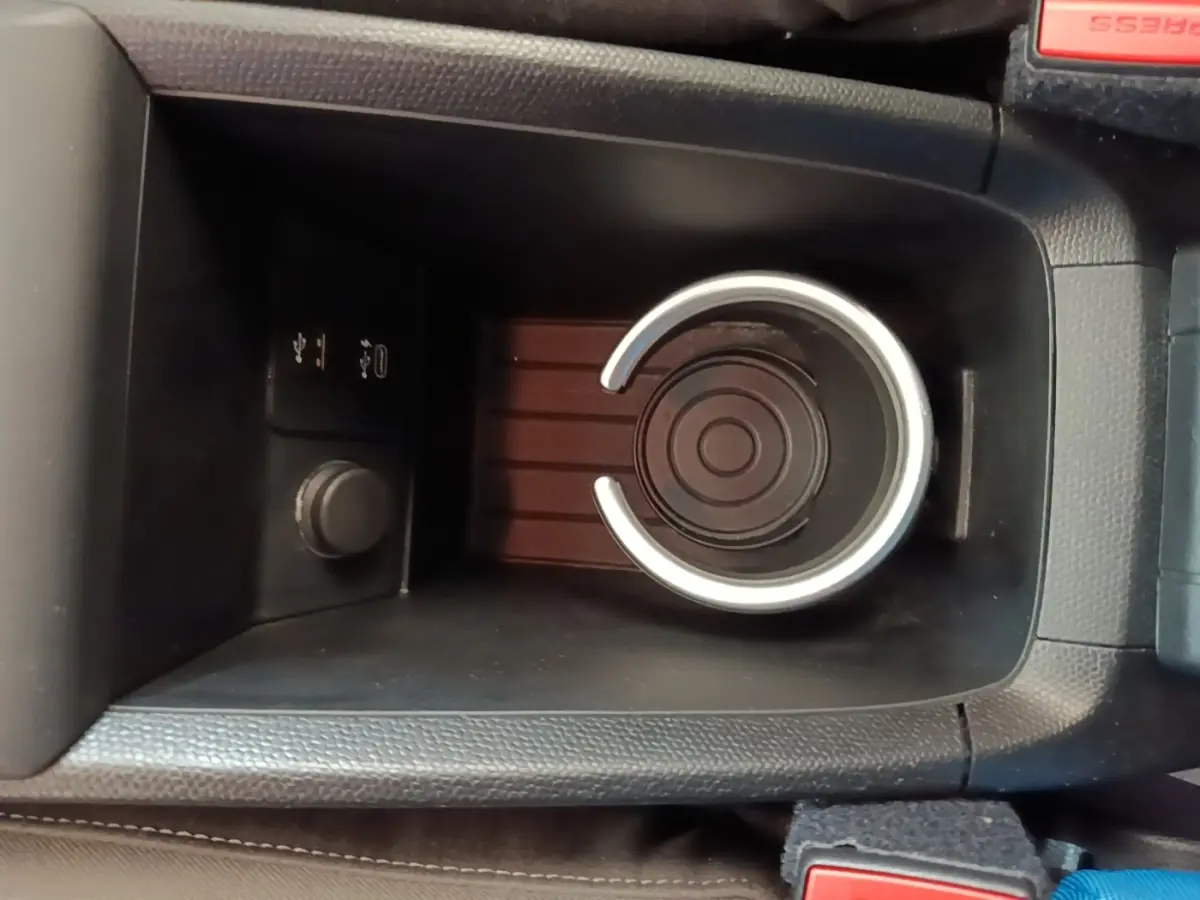 Gros plan sur le porte-gobelet central noir et les prises USB dans l’habitacle de la BMW i3 120 Ah Atelier.
