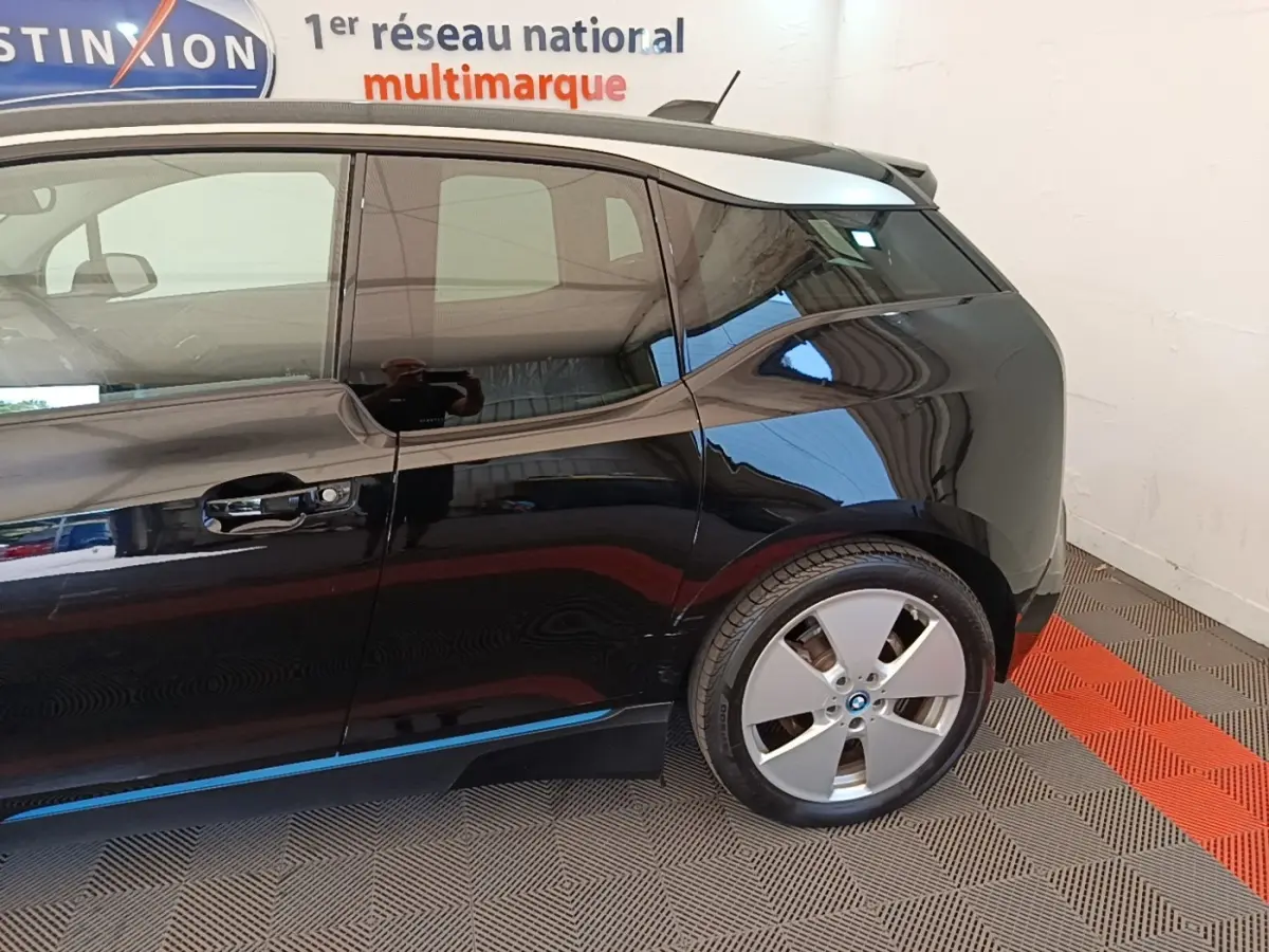 Vue latérale côté droit d'une BMW i3 120 Ah Atelier noire, mettant en valeur la porte arrière et la roue arrière.