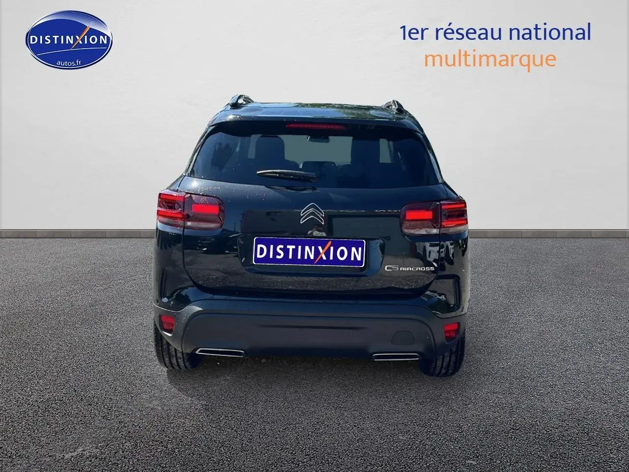 Vue arrière d'un Citroën C5 Aircross noir 2025 avec barres de toit et feux LED allumés sur sol goudronné.