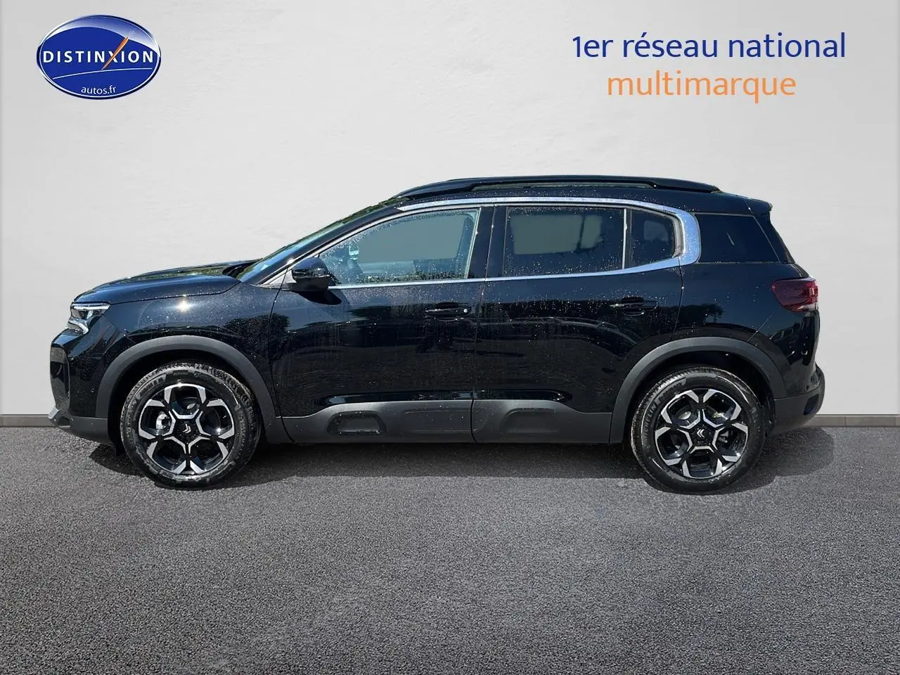 Profil côté gauche du SUV Citroën C5 Aircross noir avec jantes alu 18 pouces et barres de toit noires.
