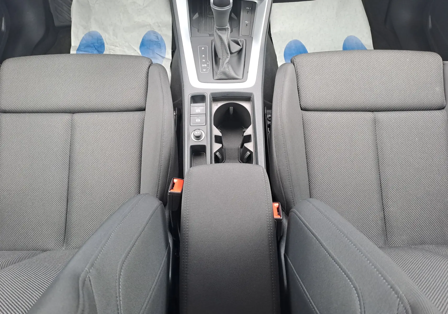 Vue plongeante sur l’intérieur noir tissu de l’Audi Q3 35 TDI 2023, avec console centrale et levier de boîte automatique.