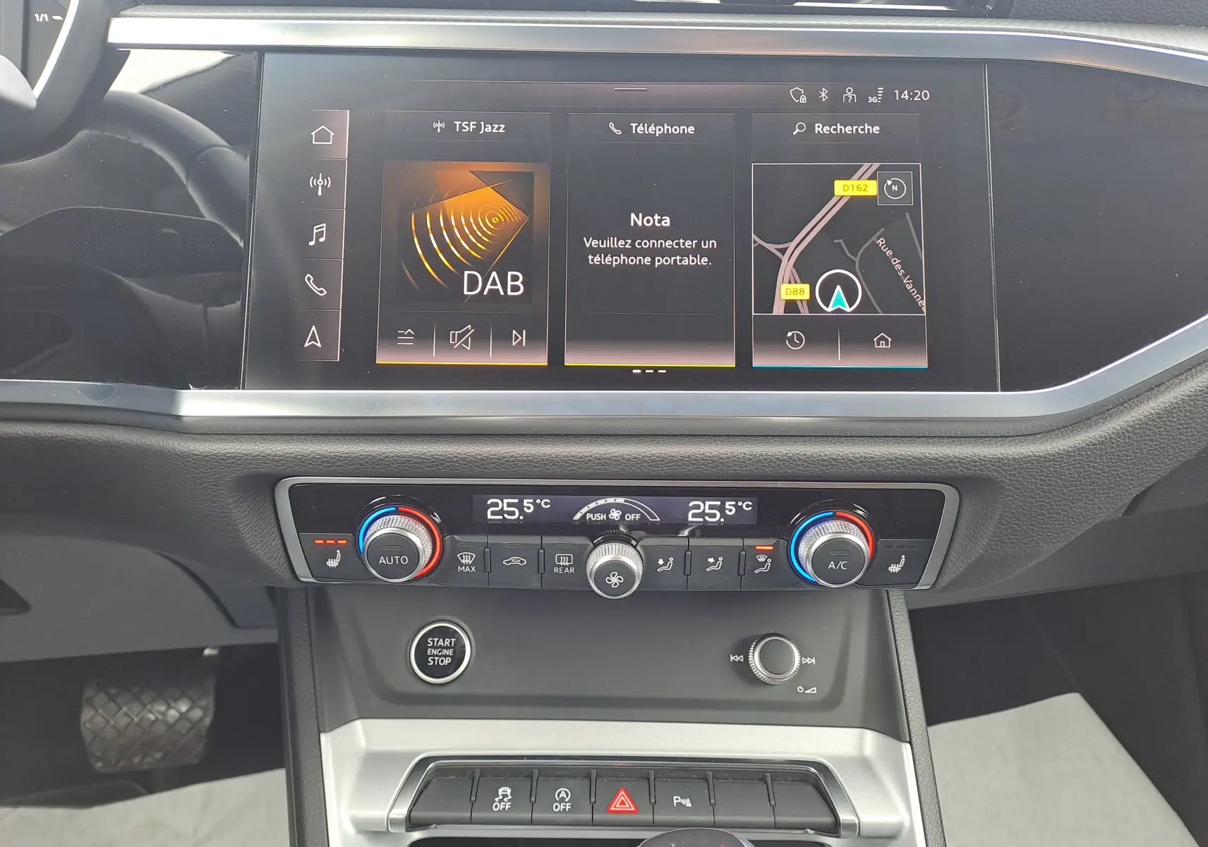 Vue rapprochée de la console centrale de l'Audi Q3 gris nano 2023 avec écran tactile et commandes climatisation.