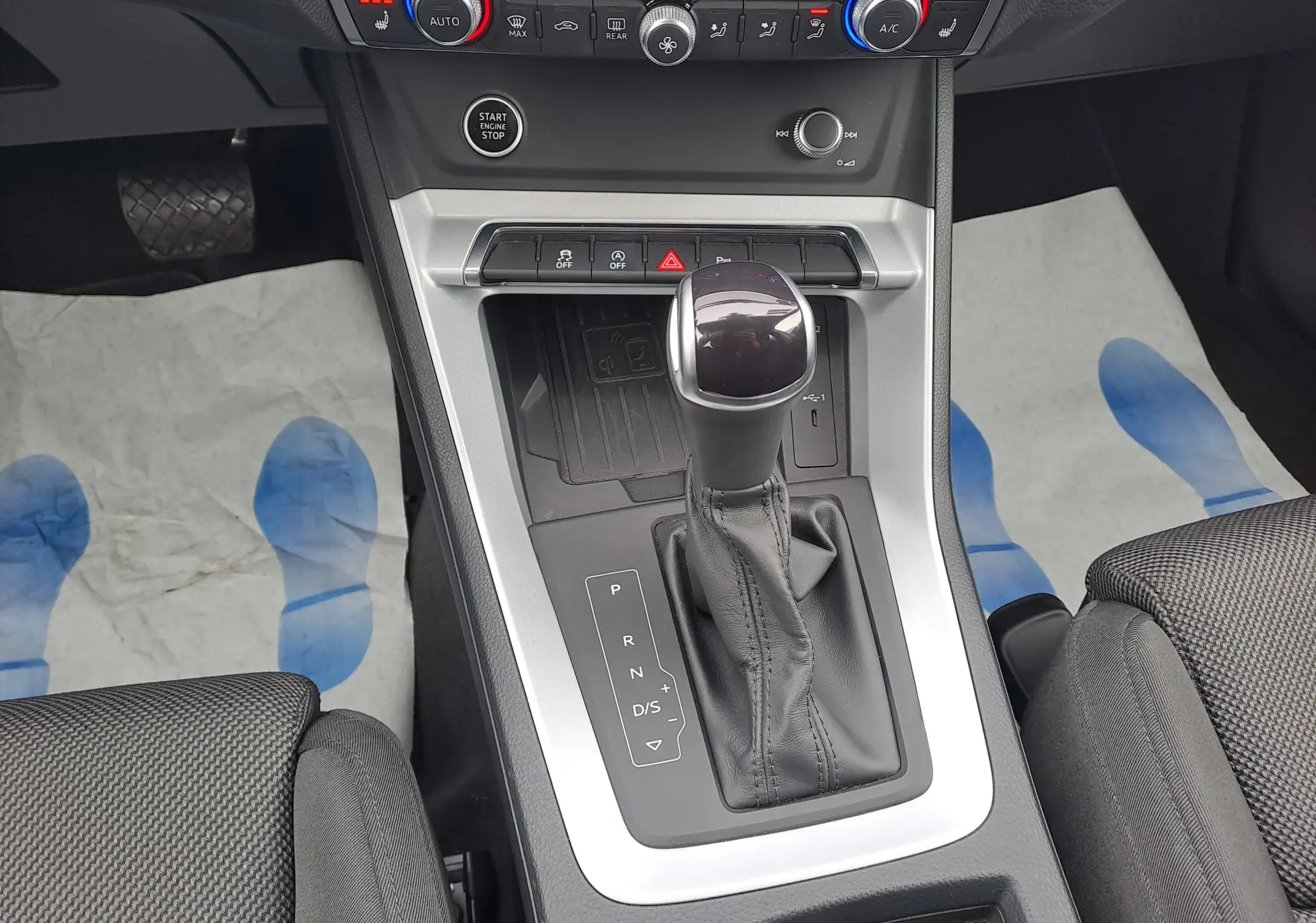 Vue rapprochée de la console centrale de l'Audi Q3 35 TDI 2023, avec levier de vitesse automatique et finition noire.