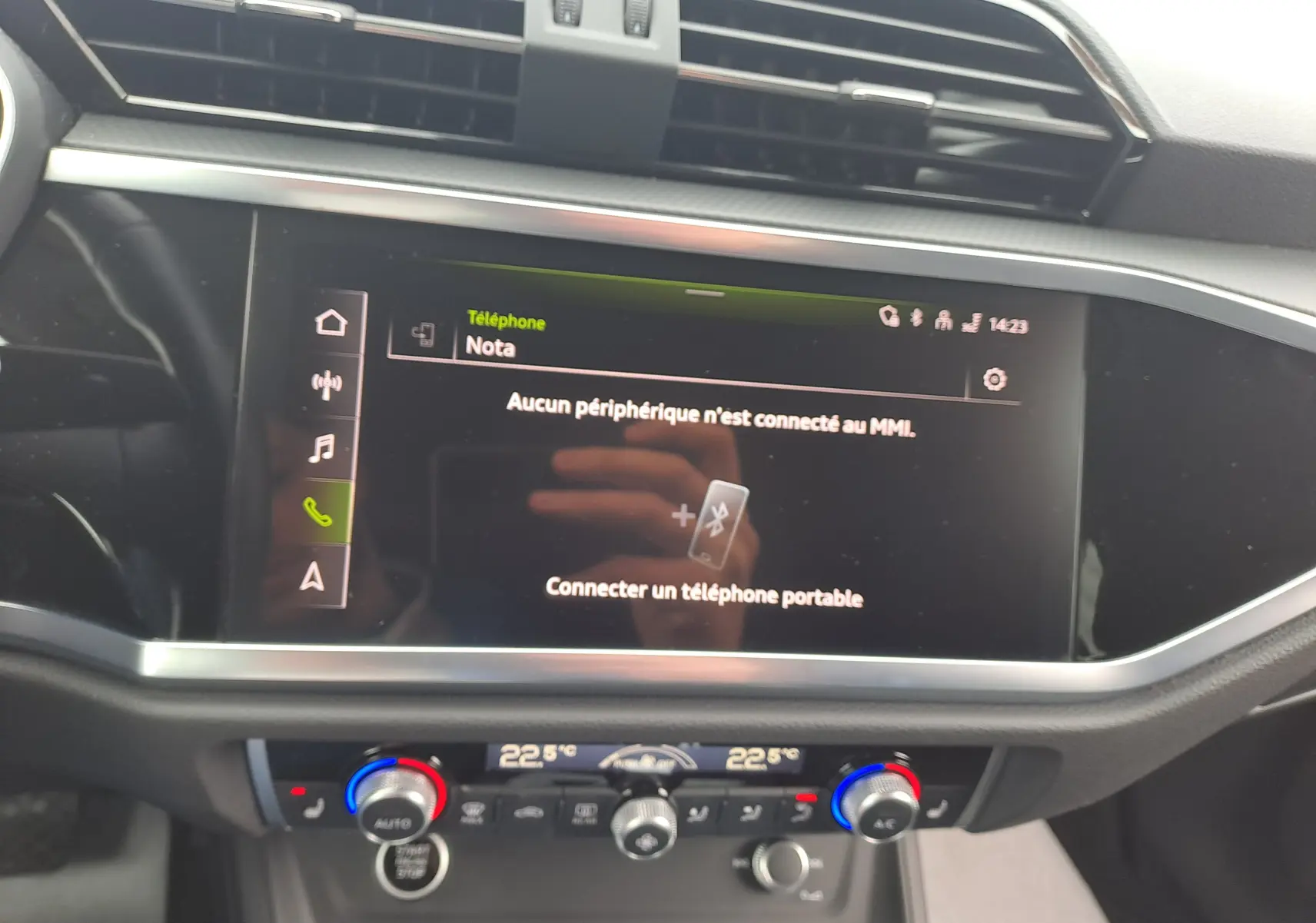 Vue rapprochée de l’écran tactile central et de la console de climatisation d’un Audi Q3 gris nano 2023.
