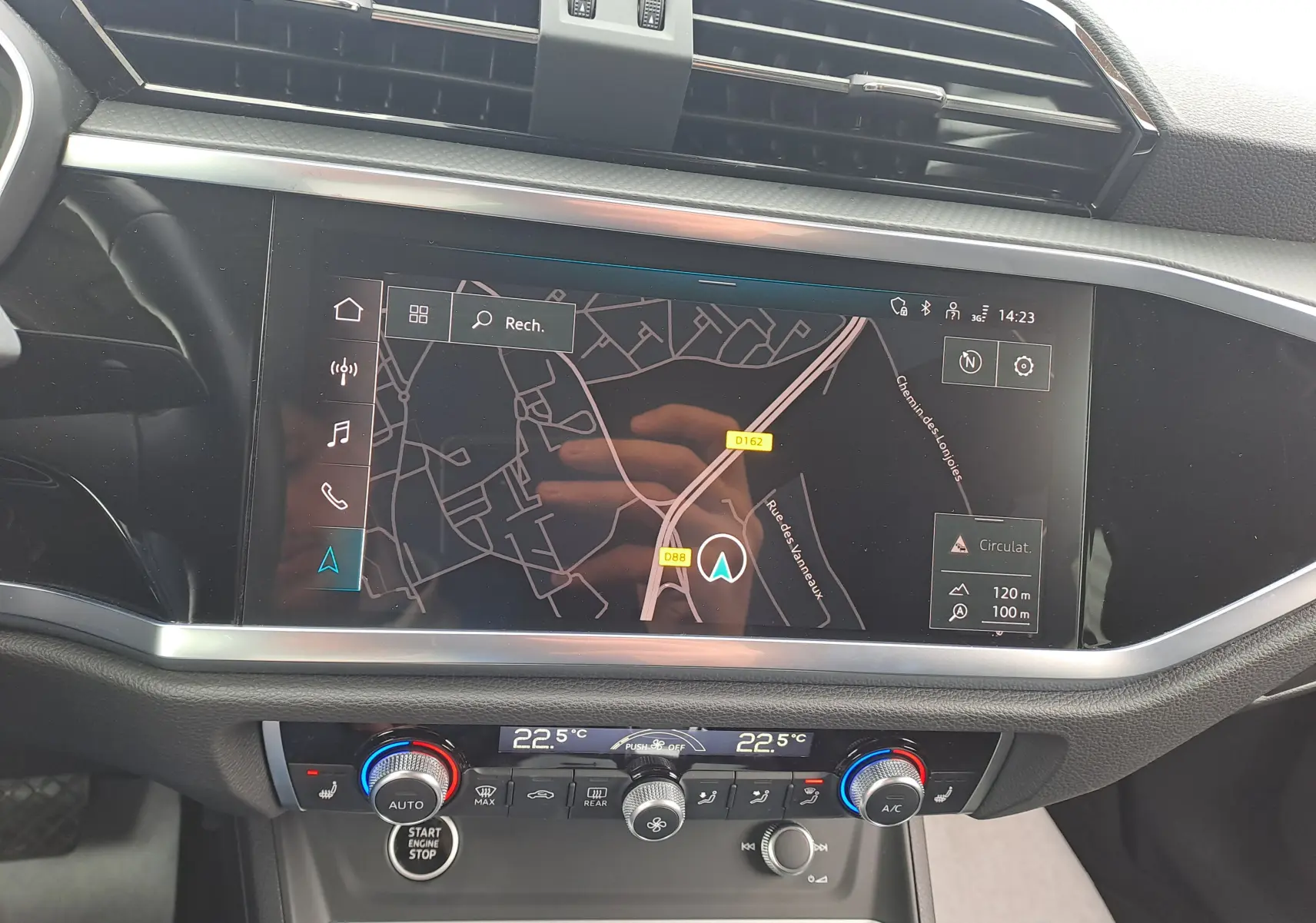 Vue rapprochée du tableau de bord de l'Audi Q3 35 TDI 2023 avec écran GPS et commandes de climatisation digitales.