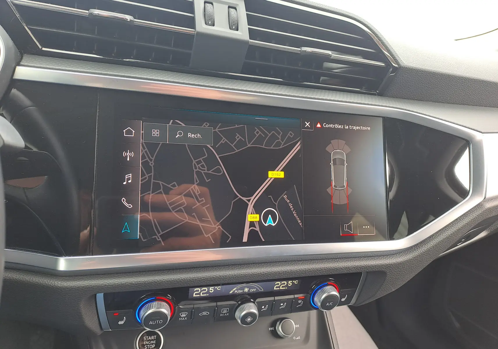Vue rapprochée de l’écran central tactile et de la console de climatisation du tableau de bord d’un Audi Q3 gris Nano 2023.