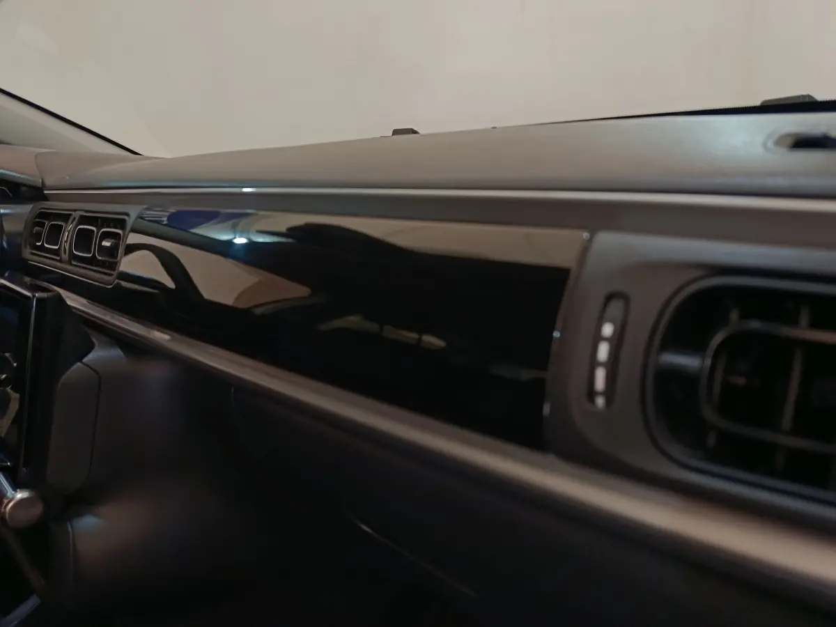 Vue rapprochée de la planche de bord noire brillante côté passager dans une Citroën C3 blanche 2022.