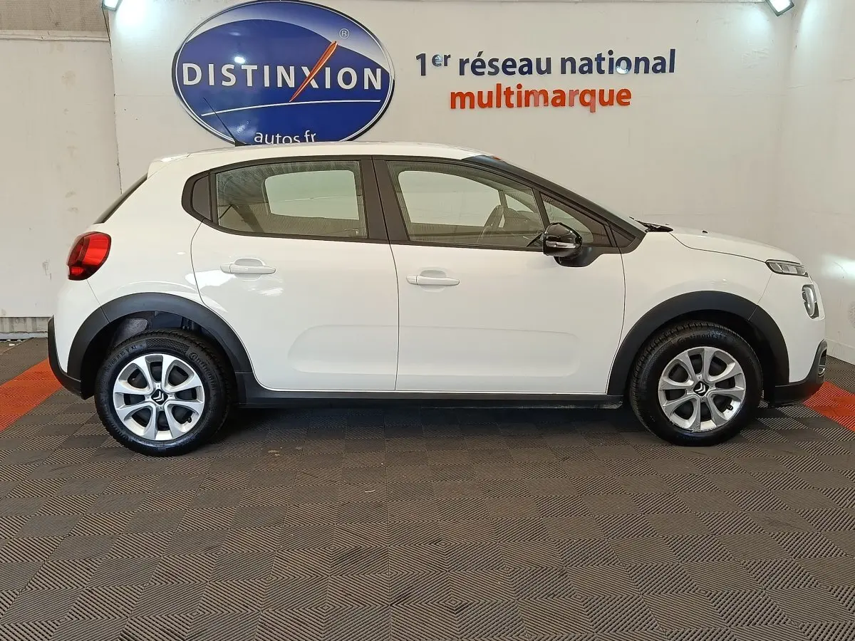 Profil droit d'une Citroën C3 blanche 2022 avec jantes alliage et protections noires sur les passages de roues.