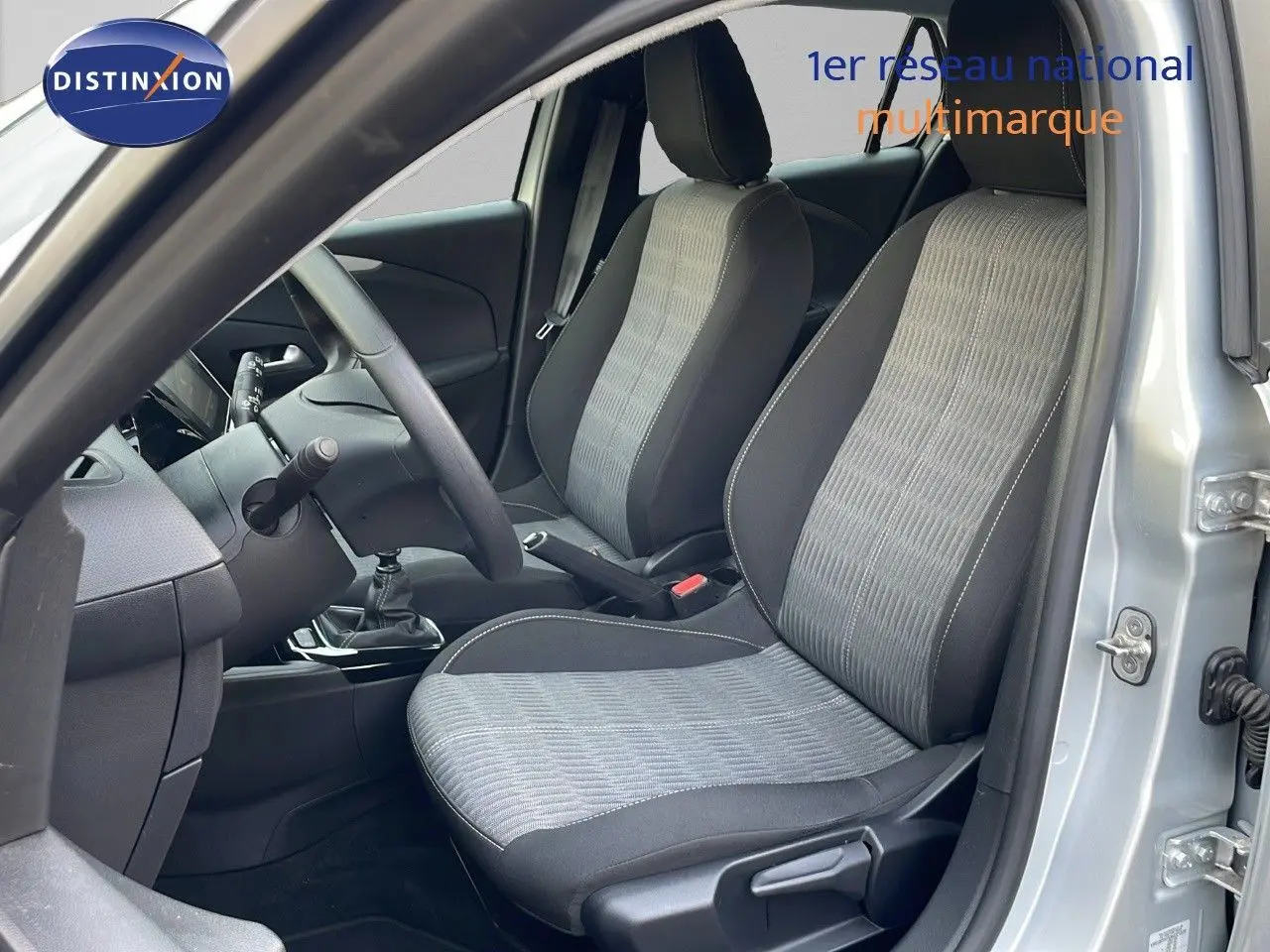 Intérieur avant droit de l'Opel Corsa gris Kristall Metal 2022, sièges tissu bi-ton et boîte manuelle visible.
