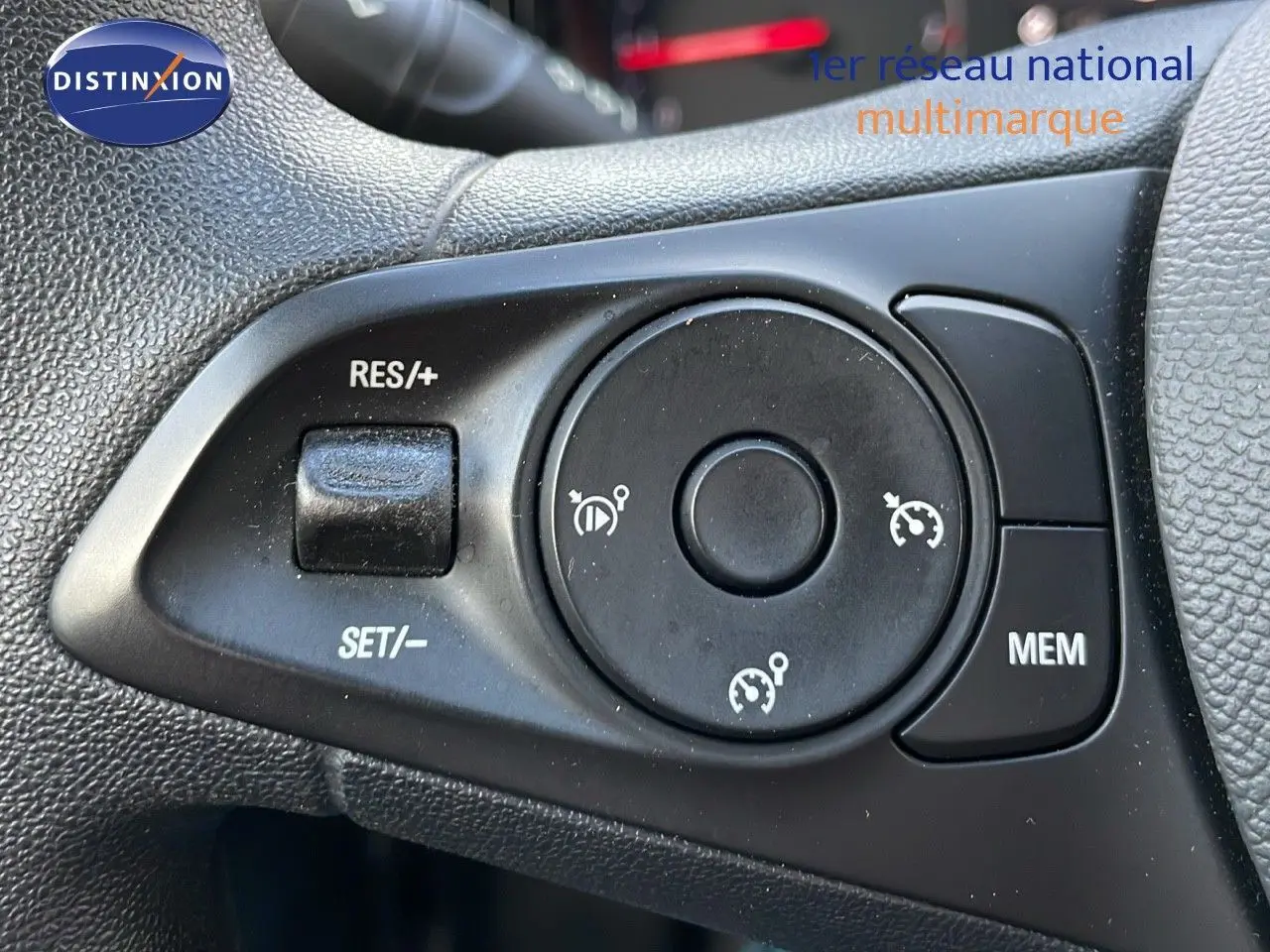 Gros plan sur les commandes de régulateur de vitesse au volant d'une Opel Corsa gris kristall metal 2022.