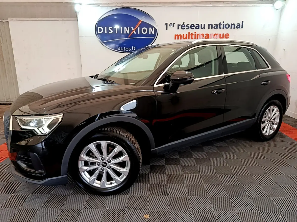 Audi Q3 35 TDI noir vue de profil côté gauche dans un showroom avec logo Distinxion en arrière-plan.