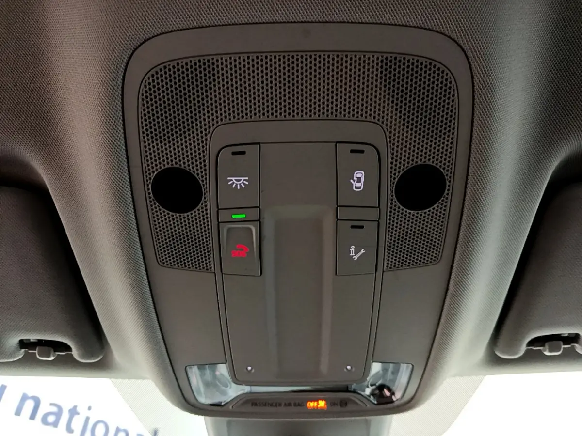 Vue en plongée sur le panneau de commande intérieur gris avec boutons d'éclairage et appel d'urgence d'un Audi Q3 noir