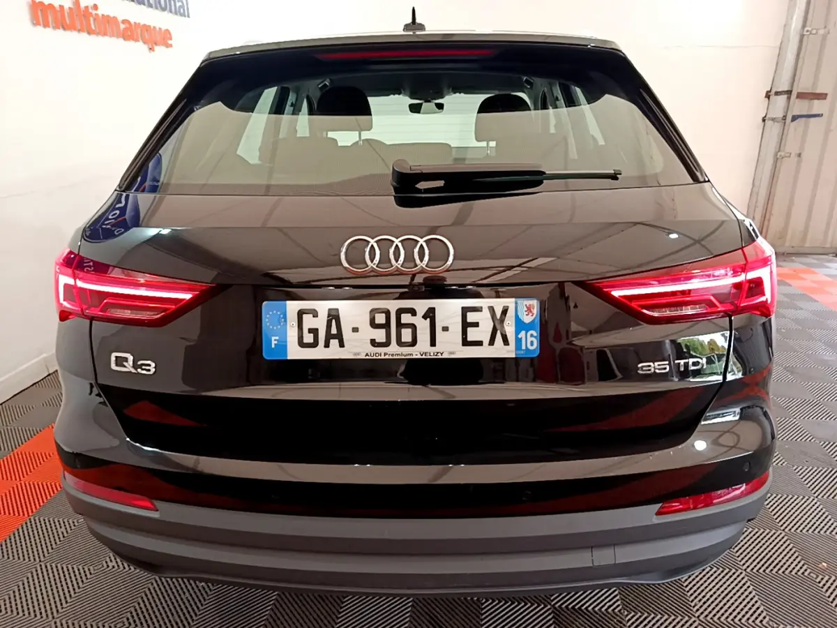 Vue arrière d'un Audi Q3 35 TDI noir avec feux LED allumés et plaques d'immatriculation françaises visibles.