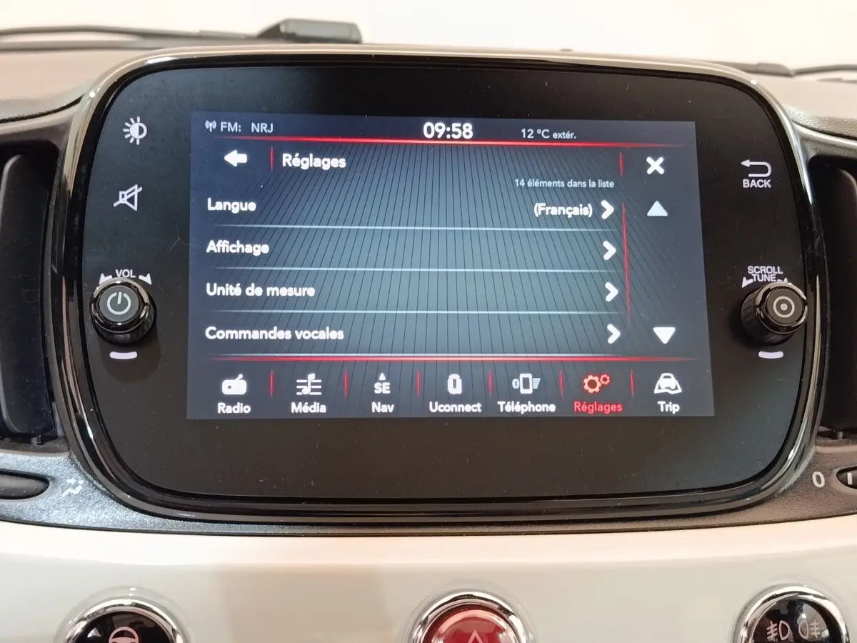 Écran tactile central de la Fiat 500 Hybrid blanc, affichant le menu Réglages en vue frontale rapprochée.