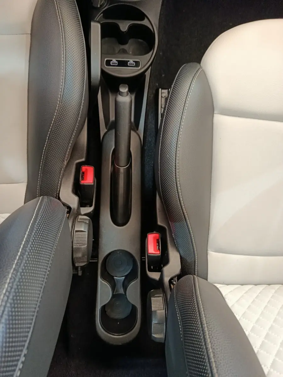 Vue plongeante sur la console centrale et les sièges bi-ton blanc et noir de la Fiat 500 Hybrid 2022.