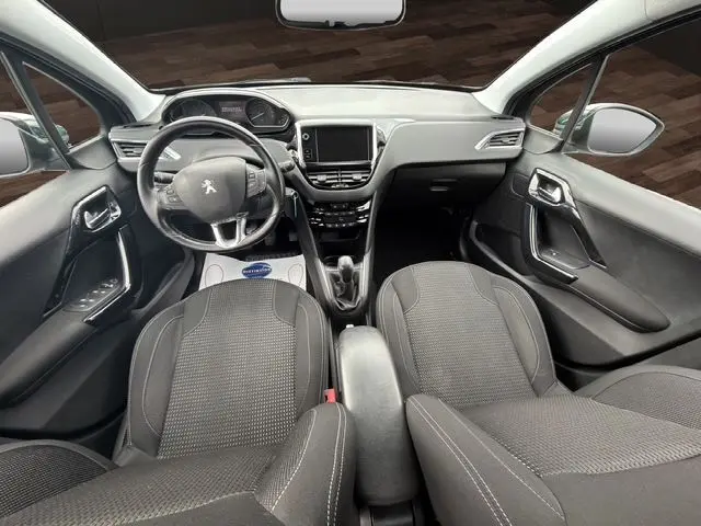Vue intérieure avant de la Peugeot 208 gris platinium, volant cuir multifonctions et écran tactile central 7 pouces.