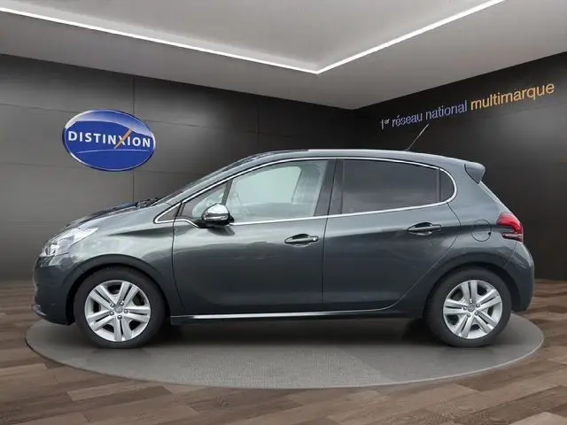 Peugeot 208 gris platinium vue de profil côté gauche, avec rétroviseurs chromés et jantes alliage.
