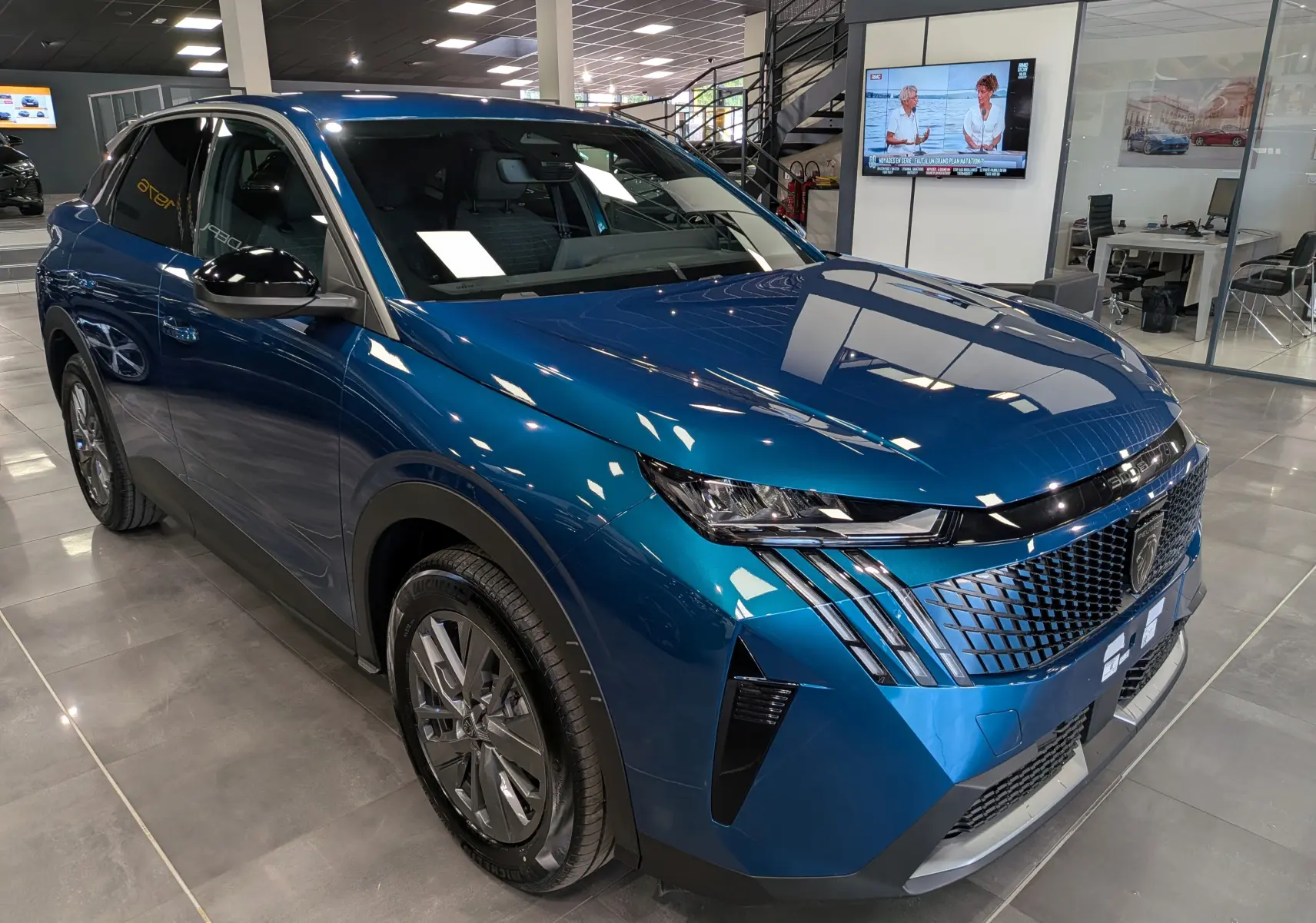 Vue 3/4 avant droite du Peugeot 3008 Hybrid 145 ch bleu Obsession, avec calandre distinctive et phares LED fins.