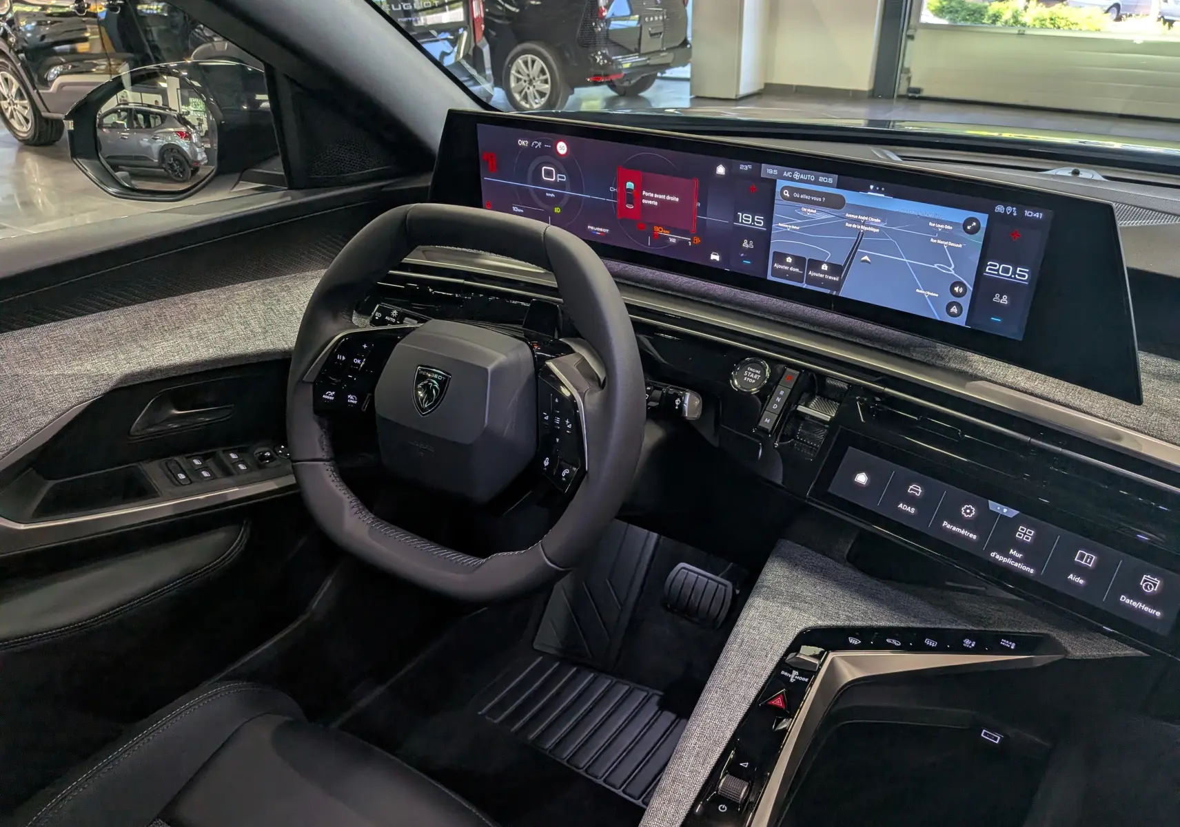 Vue intérieure côté conducteur du Peugeot 3008 Hybrid 145 Allure 2026, tableau de bord numérique et volant compact noir.