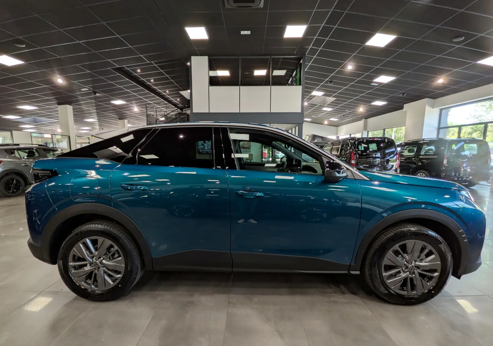 Vue latérale droite du Peugeot 3008 Hybrid 145 CH e-DCS6 Allure en Bleu Obsession, avec jantes alliage et toit noir contrasté.