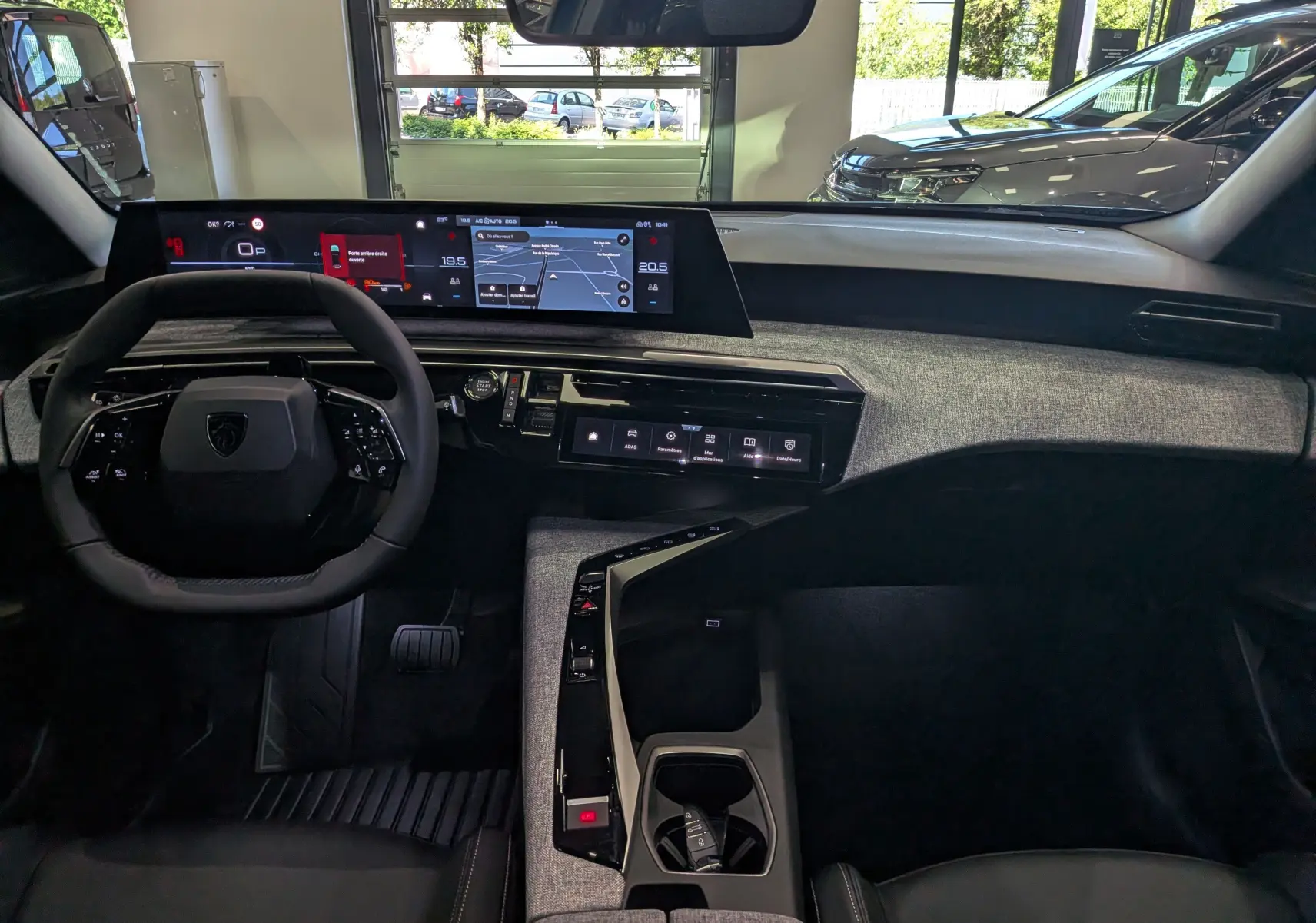 Vue intérieure du tableau de bord du Peugeot 3008 Hybrid 145 ch, avec écran numérique panoramique et finition tissu gris.